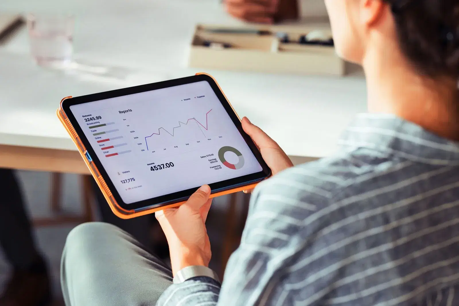 Person reviewing a financial reporting dashboard on a tablet